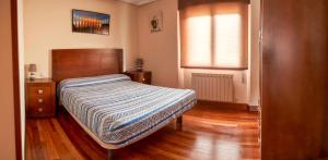 1 dormitorio con cama, ventana y suelo de madera en Chalet en Las Merindades, Nofuentes, en Nofuentes
