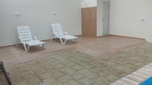 dwa białe krzesła siedzące w pokoju z podłogą w obiekcie UM POUCO DE NATUREZA NO LAR w mieście Manaus
