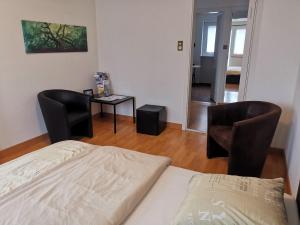 1 dormitorio con 1 cama, 2 sillas y mesa en Turicum Apartment mit Balkon und Parkplatz, en Zúrich