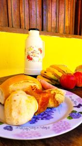 un plato de pan y fruta en una mesa en Chalé da Vó en Vargem Bonita