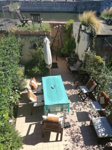un patio con mesa, bancos y sombrilla en Appartamento nel romantico Borgo San Giuliano, en Rímini