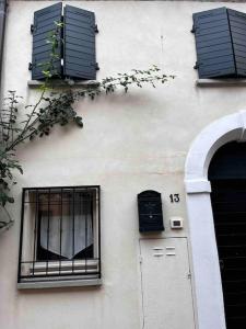 里米尼的住宿－Appartamento nel romantico Borgo San Giuliano，白色的建筑,设有两扇窗户和一扇门