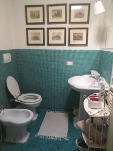baño verde con aseo y lavamanos en Appartamento nel romantico Borgo San Giuliano, en Rímini