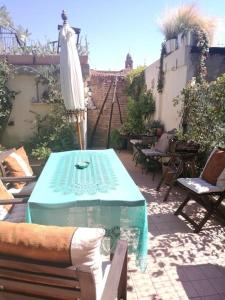 里米尼的住宿－Appartamento nel romantico Borgo San Giuliano，庭院配有桌子、遮阳伞和椅子