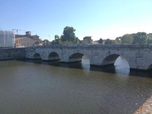 un puente de piedra sobre un río con agua en Appartamento nel romantico Borgo San Giuliano, en Rímini
