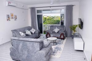 a living room with two couches and a table at Semo's Siloam apartments in Mombasa