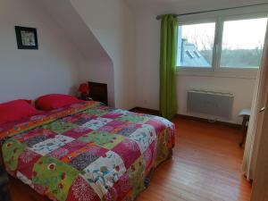 een slaapkamer met een bed en een groot raam bij gite Conan in Plourivo