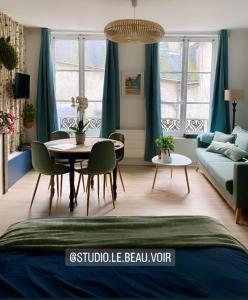 a living room with a table and a couch at Studio 4 personnes aux pieds du château de Blois avec expérience de dormir sous les aurores boréales in Blois