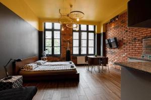 a bedroom with a bed and a brick wall at Golden Apartments Wrocław&K28 in Wrocław