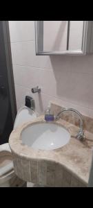 a bathroom with a sink and a toilet at Apartamento ótima localização in Torres