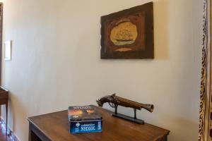 a gun sitting on top of a table with books at Era of Elegance: 1928 Classic Dwelling in Tripoli
