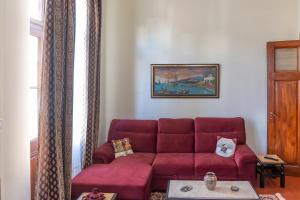 a living room with a red couch in a room at Era of Elegance: 1928 Classic Dwelling in Tripolis