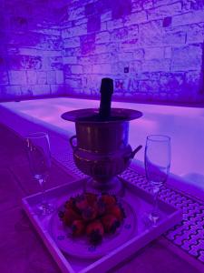 a bath tub with a bottle of wine and two glasses at Trulli e Puglia Luxury Suite in Alberobello