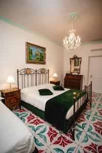 1 Schlafzimmer mit 2 Betten und einem Kronleuchter in der Unterkunft Delfini Trevi House in Rom