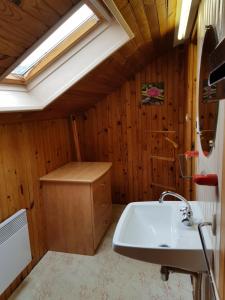 uma casa de banho com um lavatório e uma clarabóia em Mamyvonne Vacances em Tendon