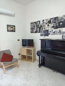 een woonkamer met een piano en een televisie bij le note di Napoli in Napels