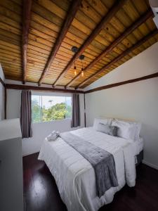 a bedroom with a large bed and a window at Flats do Pe na Areia in Abraão