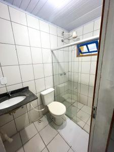 een badkamer met een toilet, een wastafel en een douche bij Pousada das Ostras in Anchieta