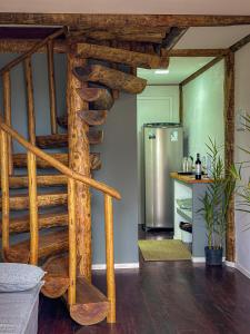 a wooden spiral staircase in a kitchen with a refrigerator at Flats Apple Ilha com Banheira in Abraão