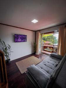 a living room with a couch and a window at Flats Apple Ilha com Banheira in Abraão