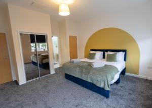 1 dormitorio con 1 cama grande y espejo grande en Stay at Waltz Gate en Horley