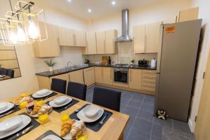 a kitchen with a table with chairs and a refrigerator at Stay at Waltz Gate in Horley