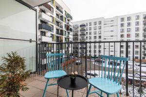 two blue chairs and a table on a balcony at SuperApart Habicha apt77 in Warsaw