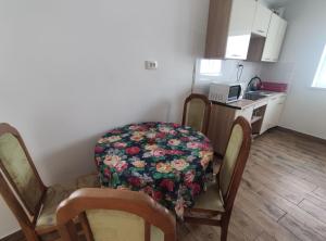 a kitchen with a table and two chairs with a flower seat at Guest House Mandrivnyi Rooms&Apartments in Yasinya