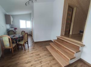 a staircase in a room with a table and a dining room at Guest House Mandrivnyi Rooms&Apartments in Yasinya