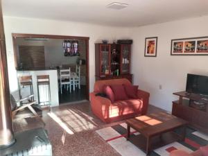 sala de estar con silla roja y mesa en Paraiso, en Salinas