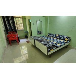 a bedroom with a bed and a red chair at Hotel HillView, Junagadh in Junagadh