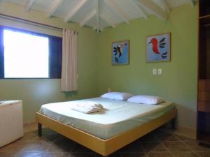 um quarto com uma cama num quarto com uma janela em QUINTAL DA MATA em São Sebastião