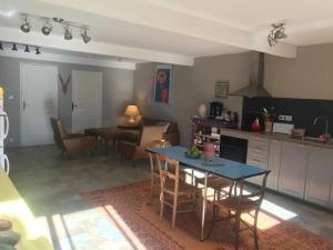 a kitchen and dining room with a table and chairs at Studio avec jardin in Coufouleux