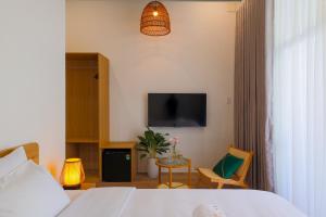 a hotel room with a bed and a tv at Lemi - Homestay in Hue in Hue