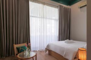 um quarto de hotel com uma cama e uma janela em Lemi - Homestay in Hue em Hue