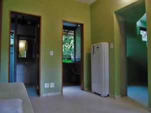 uma cozinha com paredes verdes e um frigorífico num quarto em QUINTAL DA MATA em São Sebastião