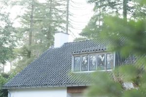 une maison avec un toit noir et une fenêtre dans l'établissement Huishotel Bed bij Bort, à Ommen