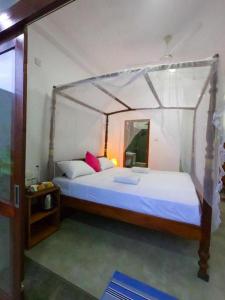 1 dormitorio con 1 cama con dosel en Asa Bay Beach Resort, en Talpe