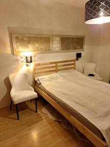 a bedroom with a bed and two chairs and a lamp at Ferienwohnung in Erlauf