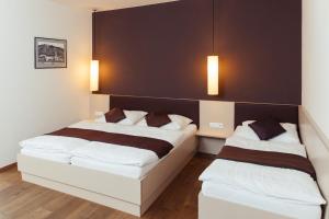um quarto com duas camas e duas luzes na parede em WEINBLICK & WEINGUT Grafinger em Senftenberg