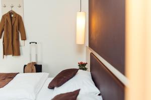 um quarto com uma cama e um casaco pendurado numa parede em WEINBLICK & WEINGUT Grafinger em Senftenberg