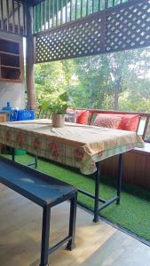 una cama sobre una mesa con un banco en Parsakfamilyhouse9rooms, en Hang Dong
