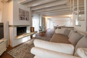 sala de estar con sofá blanco y chimenea en Ca Paradiso, en Caprino Veronese