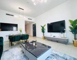 a living room with a table and a tv at 2BR,Direct to Dubai mall, Burj Khalifa52 in Dubai