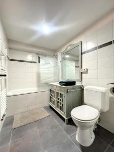 uma casa de banho com um WC, uma banheira e um lavatório. em Cosy Apartment Brussels - Flagey em Bruxelas