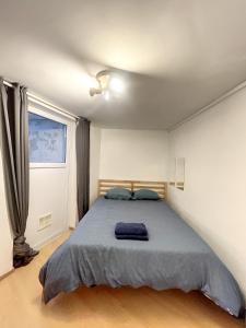 um quarto com uma cama com um cobertor azul em Cosy Apartment Brussels - Flagey em Bruxelas