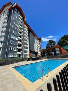 a swimming pool in front of two tall buildings at Depto. con Vista al Volcan in Villarrica