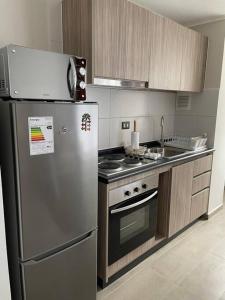 a kitchen with a stainless steel refrigerator and a stove at Depto. con Vista al Volcan in Villarrica