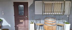 una casa con un barril y sillas y una puerta en RutSuite en ‘Afula