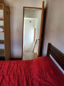 a bedroom with a red bed and a mirror at La Bonaerense departamento centrico in Esquel